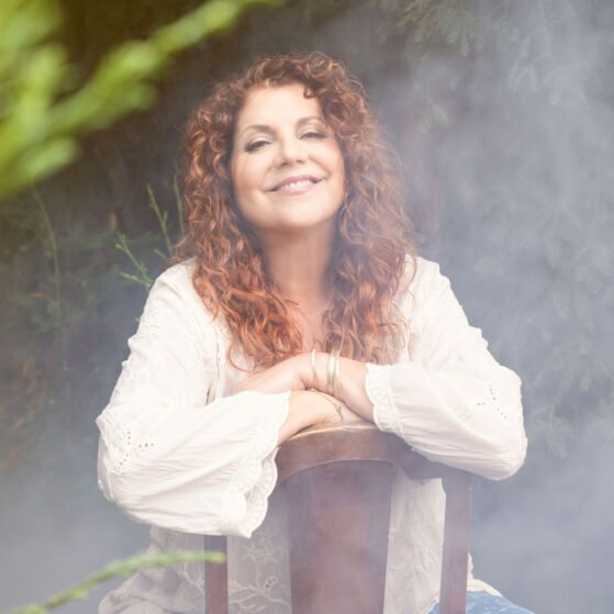 Elaine Lucia singer-songwriter recording artist sitting in a chair in front of redwood tree on a foggy morning