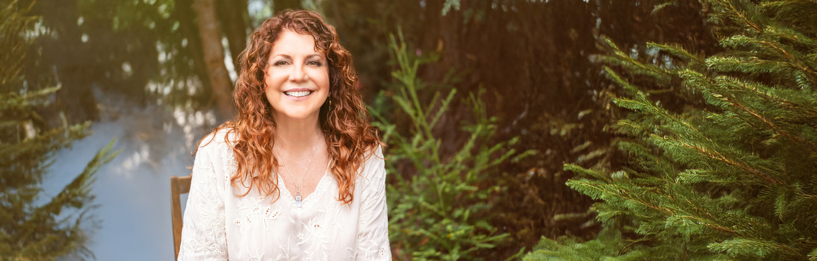 Elaine Lucia sitting in redwoods smiling